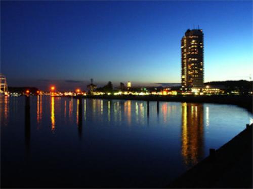Ostsee Charter: Travemünder Hafeneinfahrt bei Nacht - rechts das Maritim-Hotel